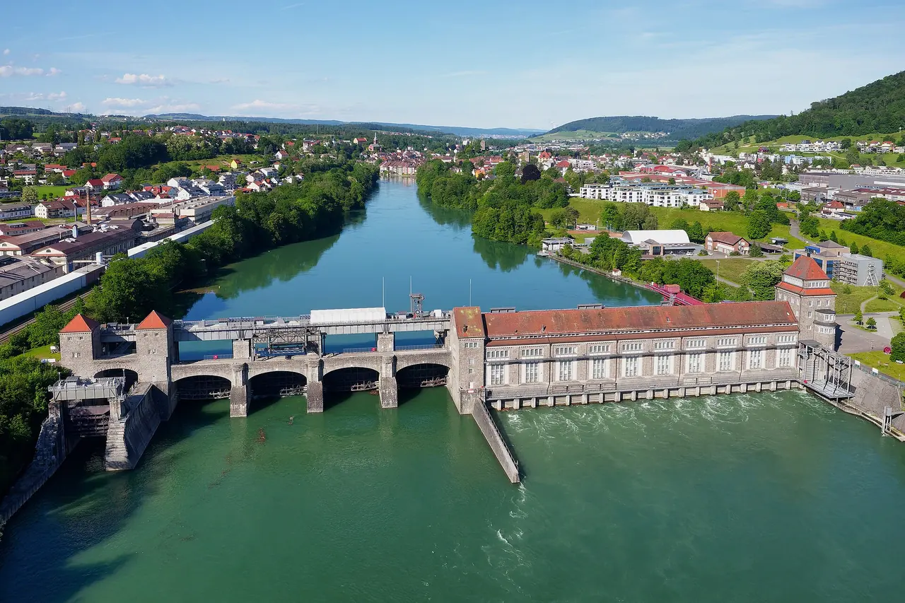 Das Rheinkraftwerk Laufenburg mit Wehr und Maschinenhaus, im Hintergrund die beidseitig des Flusses gewachsene Stadt.